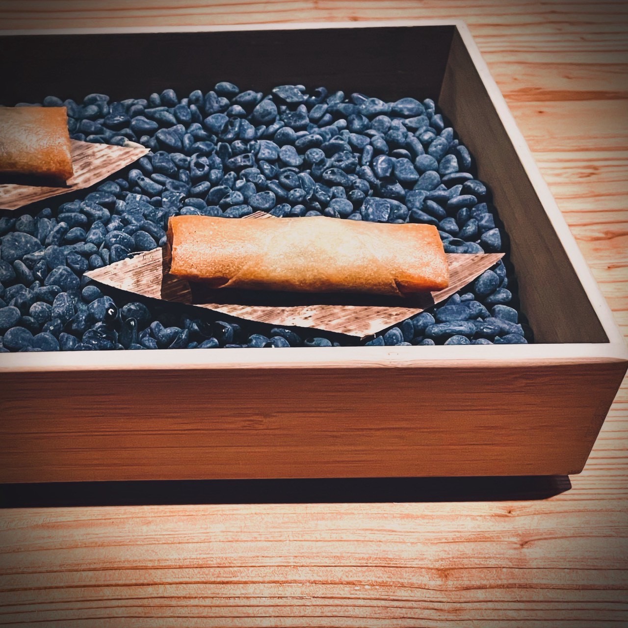 木箱と石を使った静物的な一品